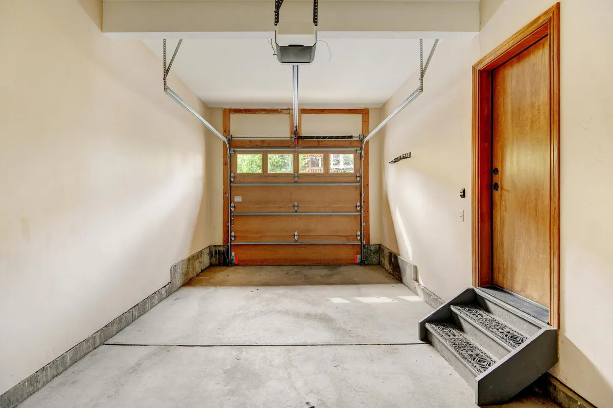 A practical garage interior, showing a garage door, stairs leading into the home, and space for parking or storing outdoor gear. The setup is ideal for stowing adventure equipment or safely parking vehicles.